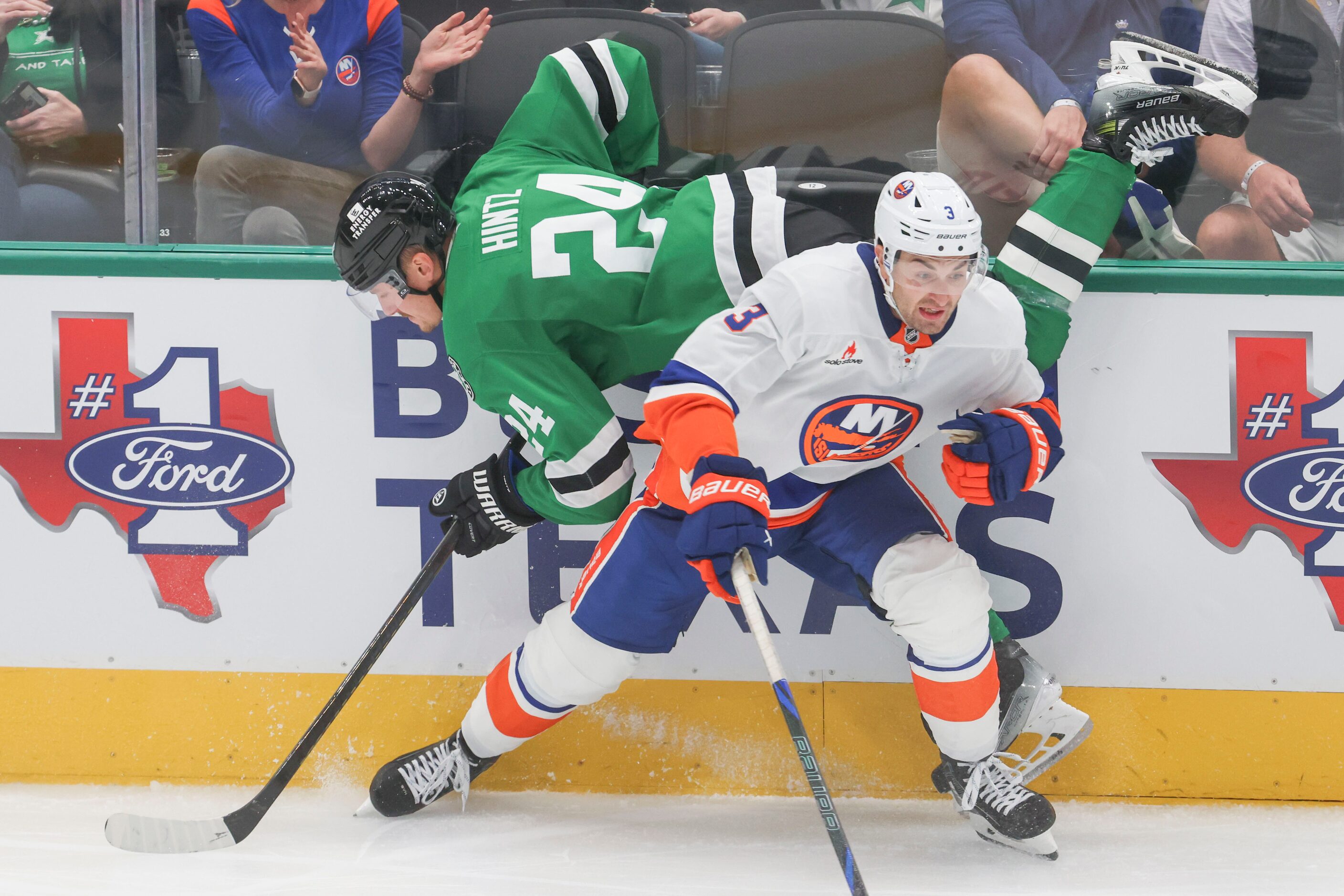 Dallas Stars center Roope Hintz (back) trips over New York Islanders defenseman Adam Pelech...