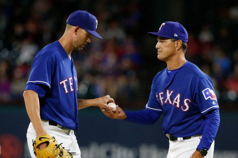 Texas Rangers starting pitcher Mike Minor, left, gives the ball to interim manager Don...