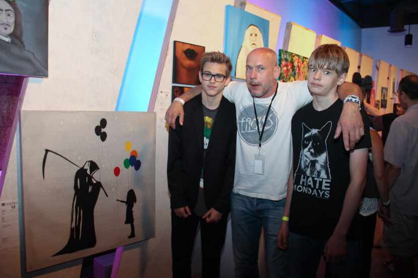 Artist Kenneth Crain with his donated piece with his two sons Parker and Spencer at Art Con...