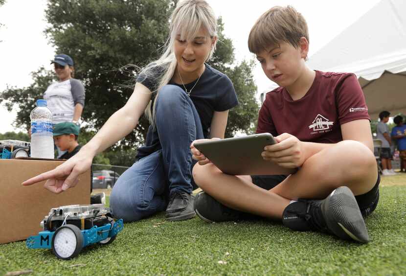 Meagan Coffer, left, and 11-year-old Ryan Martin program a robot during the Frisco Family...
