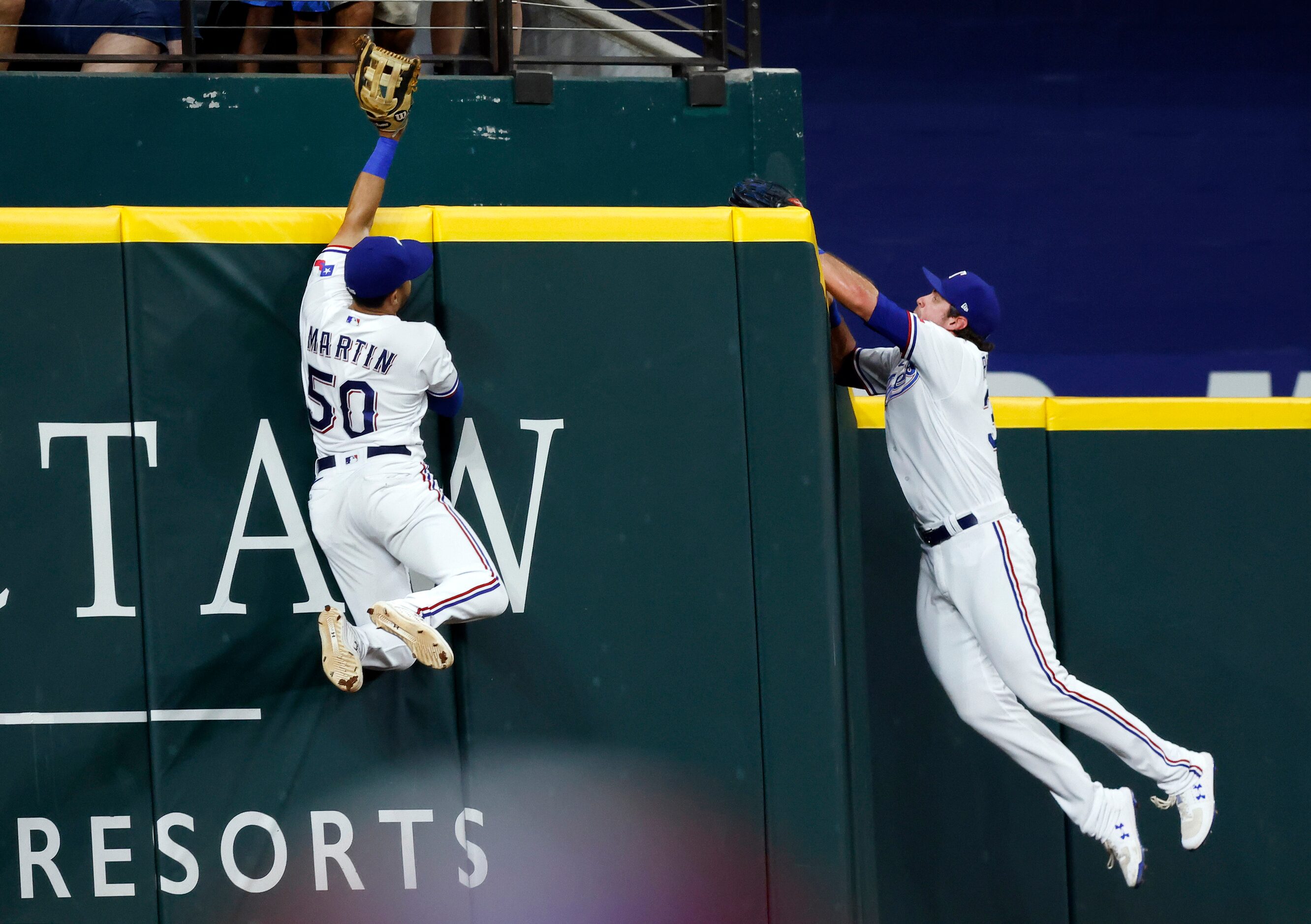 Texas Rangers left fielder Jason Martin (50) and center fielder DJ Peters (38) fly to the...