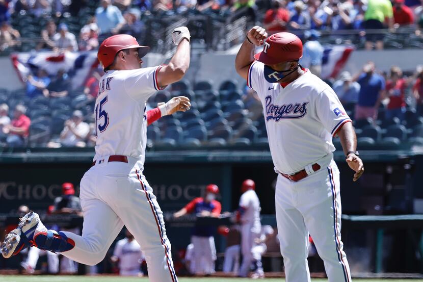 Texas Rangers Nick Solak (15) is congratulated by third base coach Tony Beasley after his...