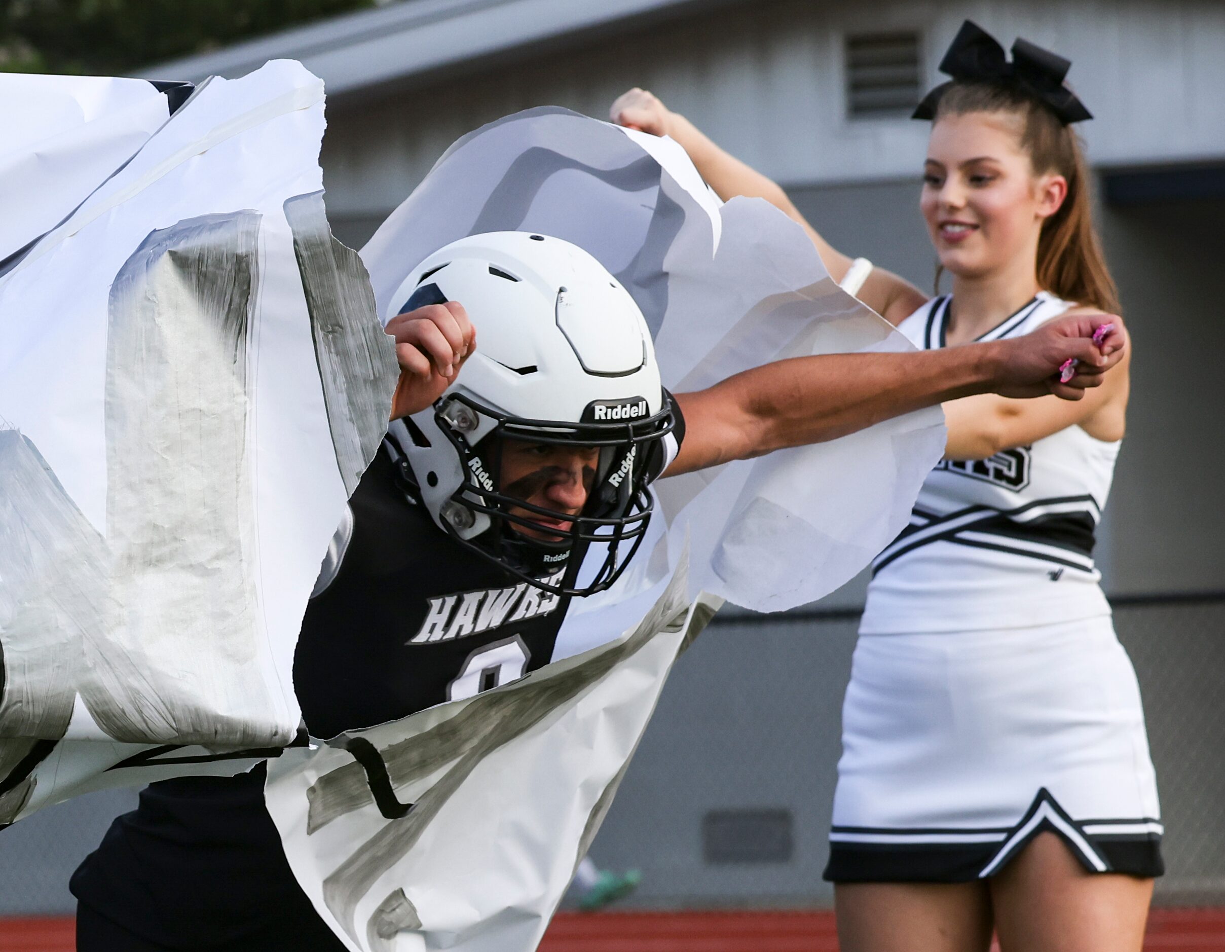 Cistercian Preparatory School Stephen Cox (8) lunges through a paper sign before the...