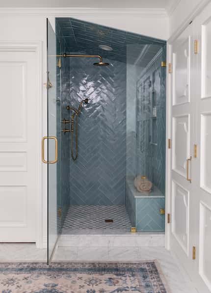 A bold blue tone in this small shower designed by Ashleigh Graber helps create the illusion...