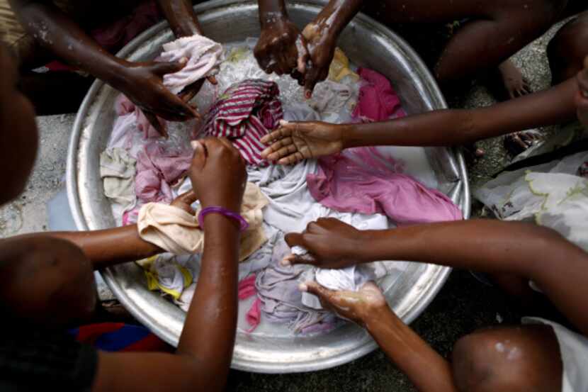Children wash clothes at Haitian Children's Rescue Mission in Haiti. Albert L. Reyes,...