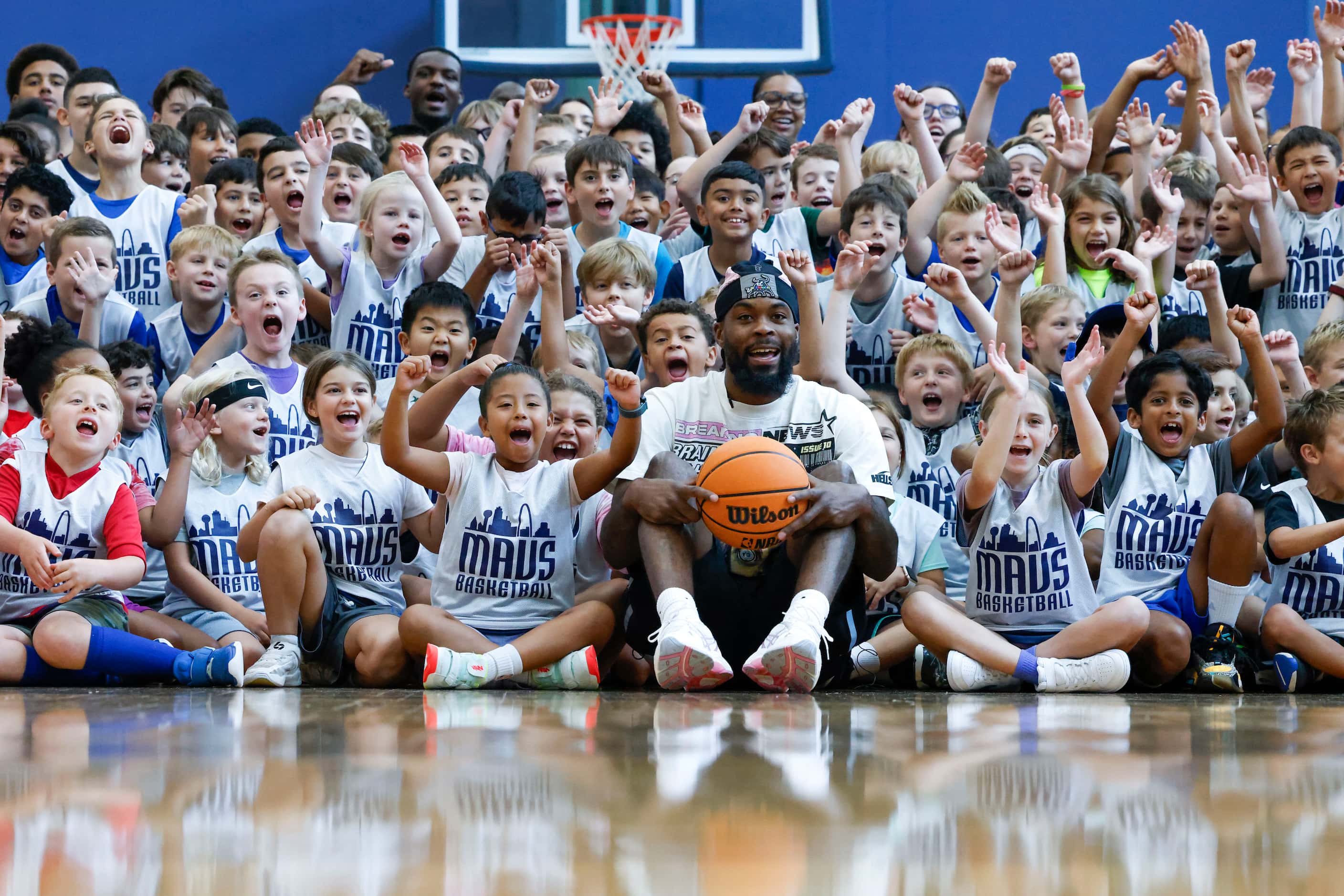 Dallas Mavericks’ Naji Marshall, cheers with young basketball campers during a Hoop Camp,...