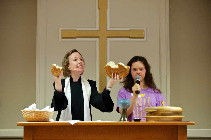 Associate Pastor Ramsey Patton, left, breaks bread as Constance Lewis recites the communion...