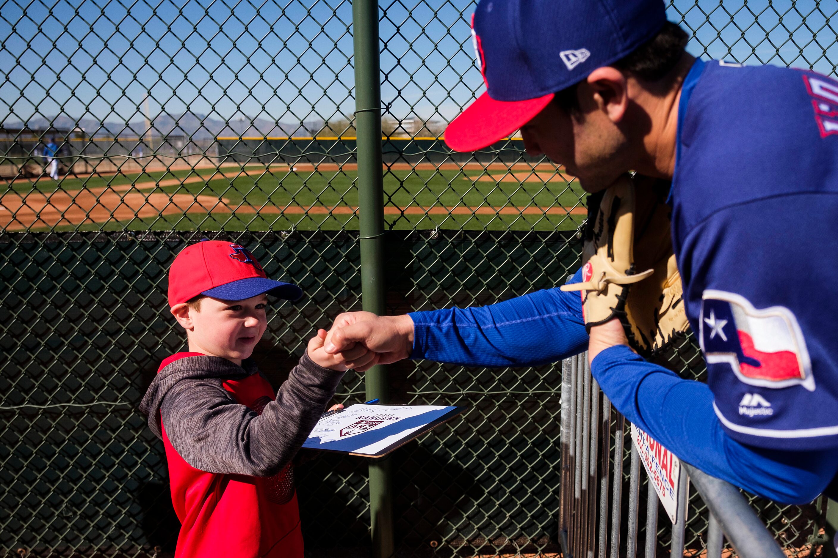 Tyler Weisz, 7, from Highland Village, Texas,gets a fist bump from Texas Rangers infielder...