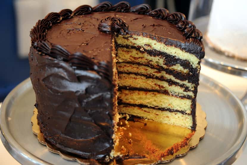 A slice of yellow cake with dark chocolate frosting from Cake Bar in Trinity Groves evokes...
