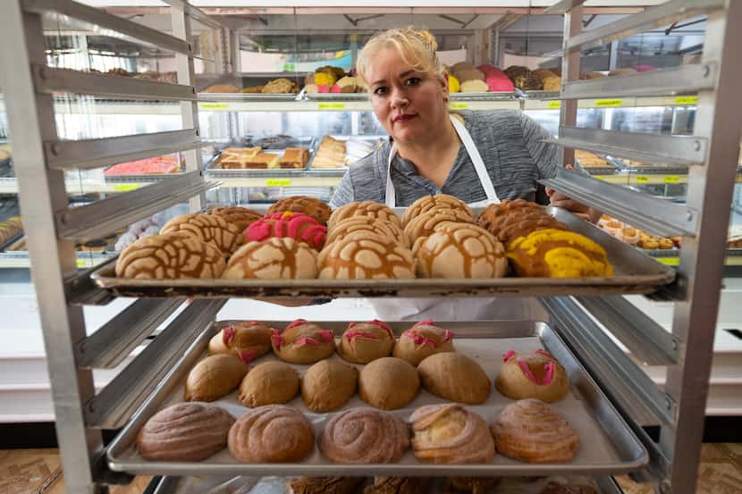 Owner Cristina Enriquez of Panaderia La Hacienda loads a tray of Mexican style sweet bread,...