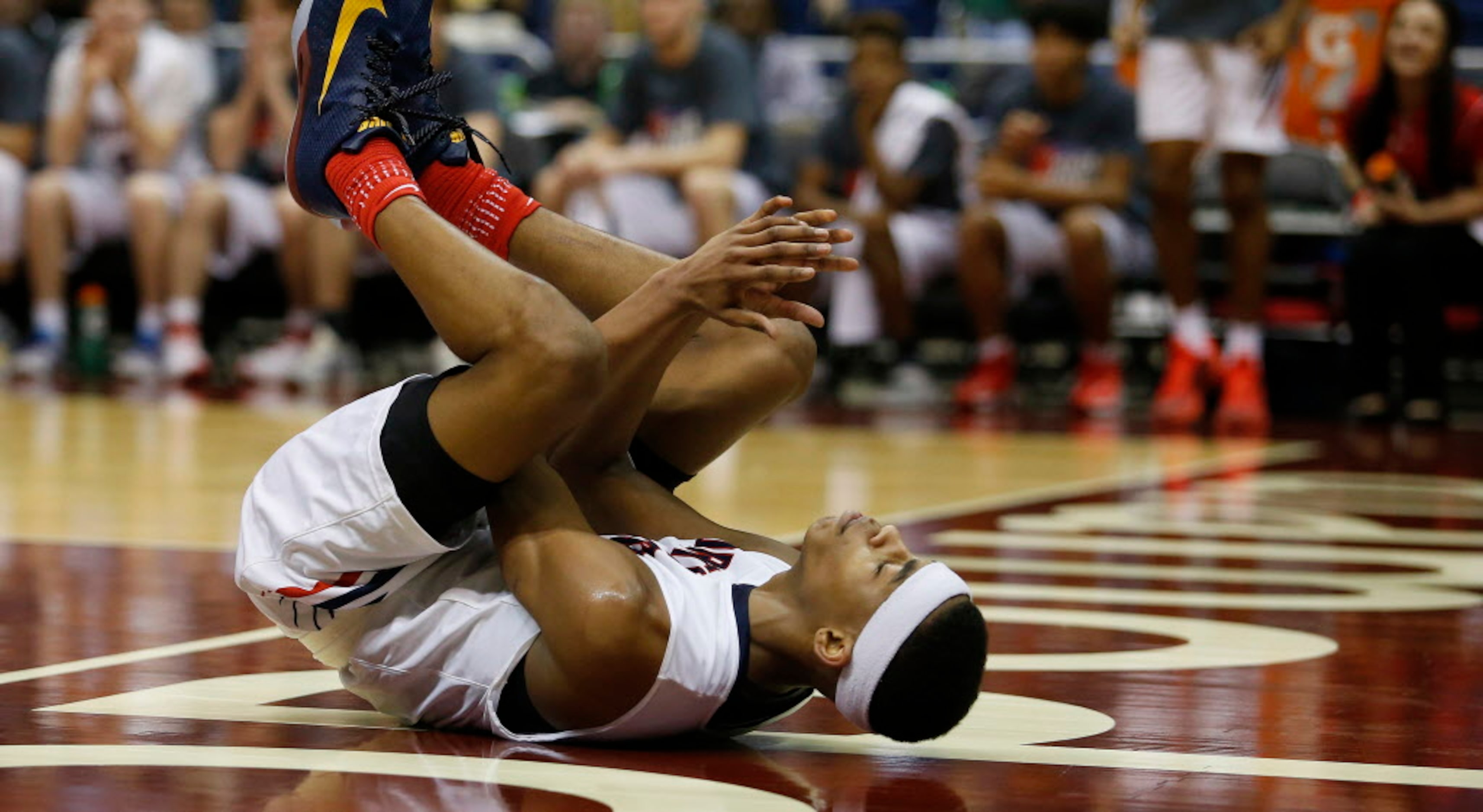 Justin Northwest's Avery Anderson (3) rolls after colliding under the basket during the...