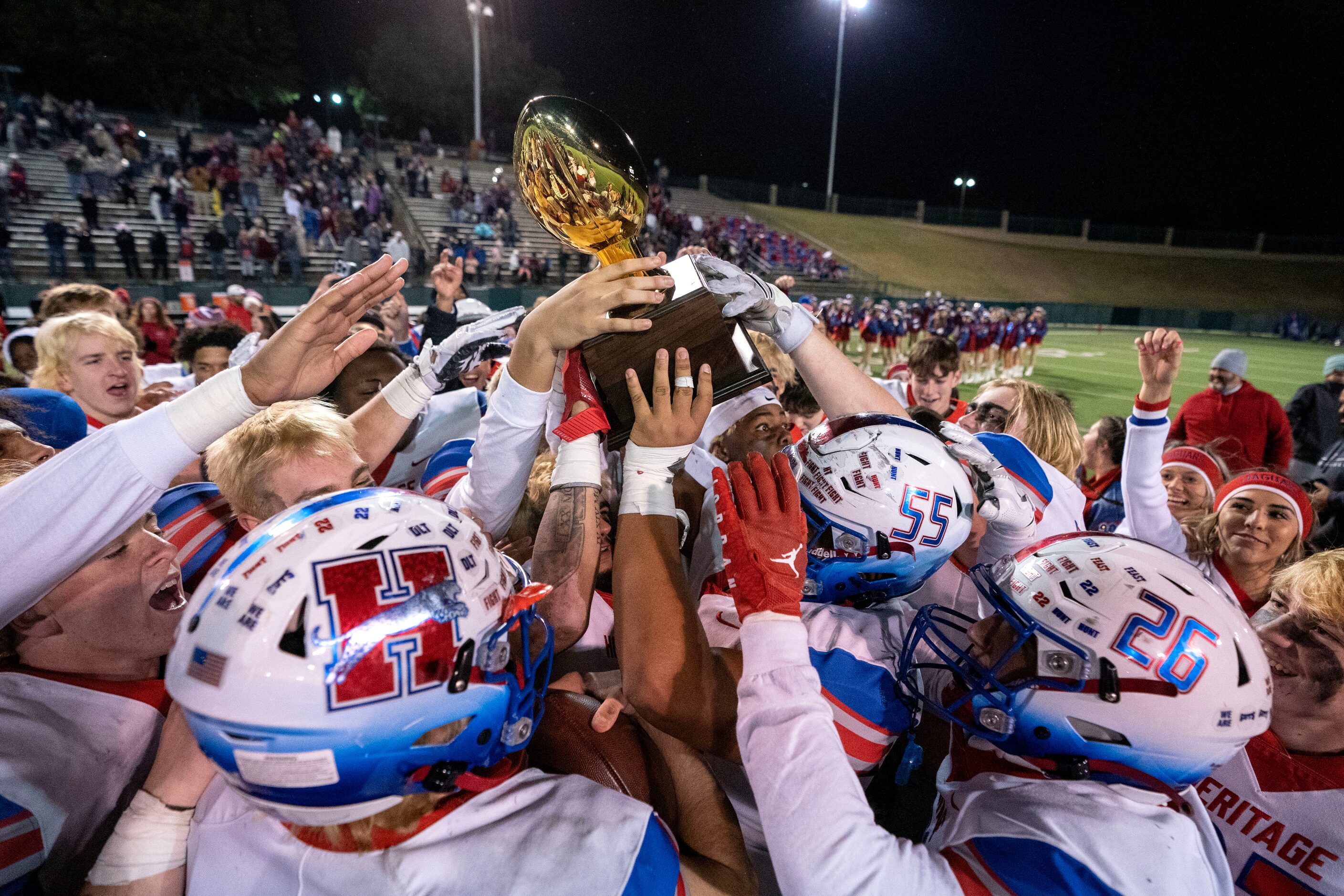 Midlothian Heritage players celebrate with the trophy after defeating Crandall 45-37 in an...