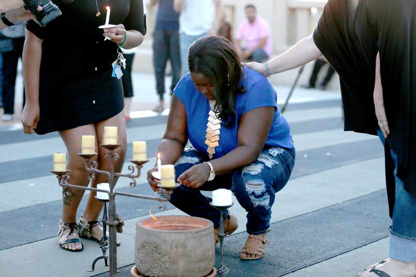 Matisha Ward, daughter of Antoinette Brown, pauses after lighting a candle during a vigil...