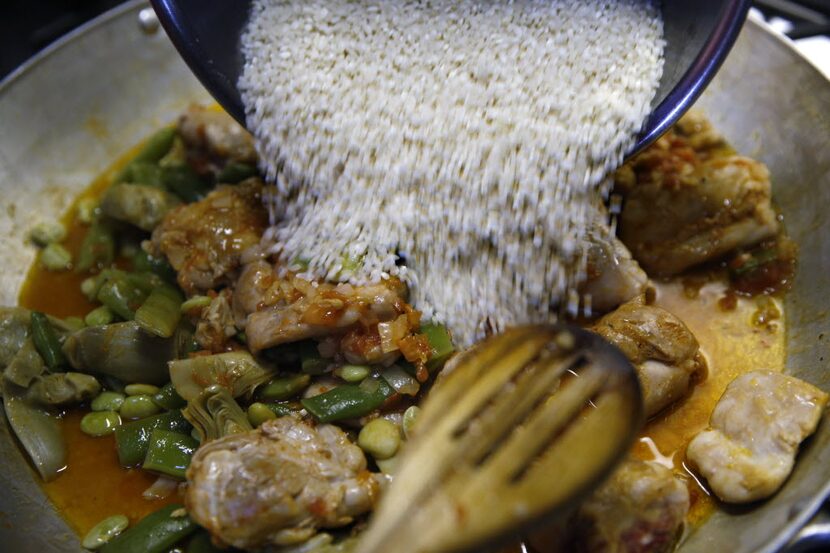 Tina Danze adds rice to the paella. 