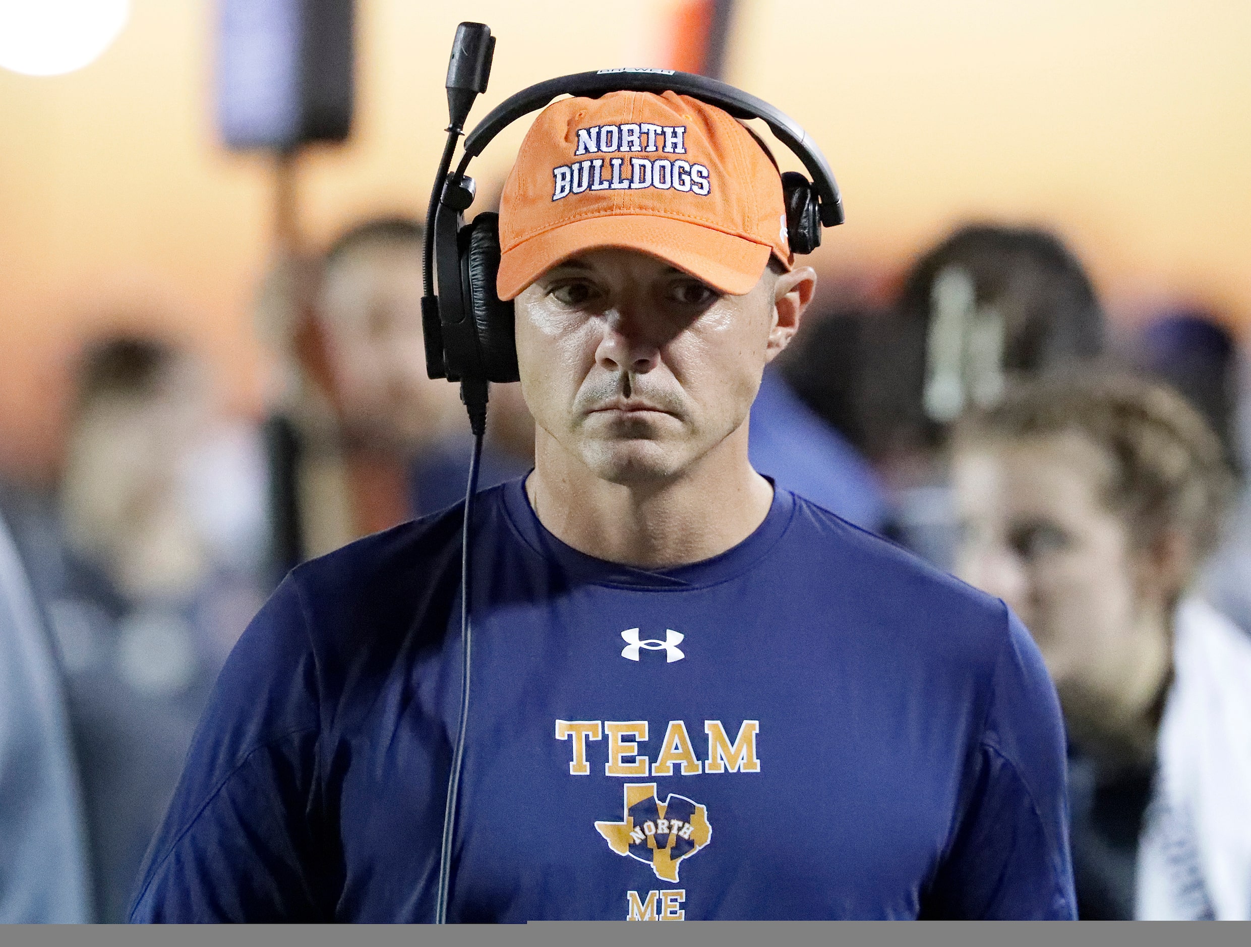 McKinney North High School head coach Kendall Brewer listens to his headset during the first...