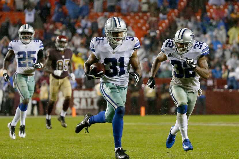 Dallas Cowboys free safety Byron Jones (31) returns an interception for a touchdown next to...