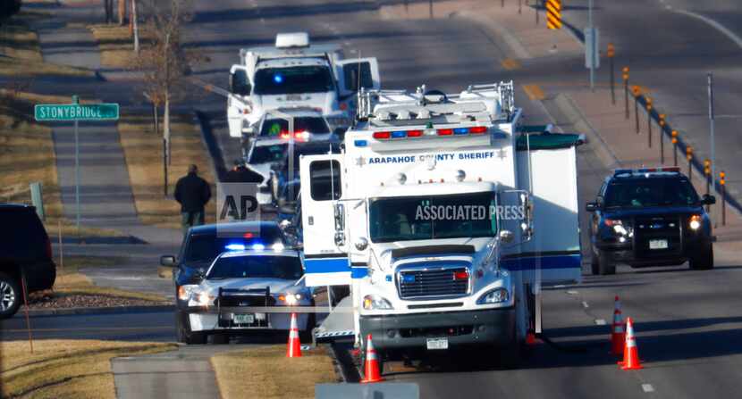 An investigator heads to the scene of shooting Sunday in Highlands Ranch, Colo. Authorities...