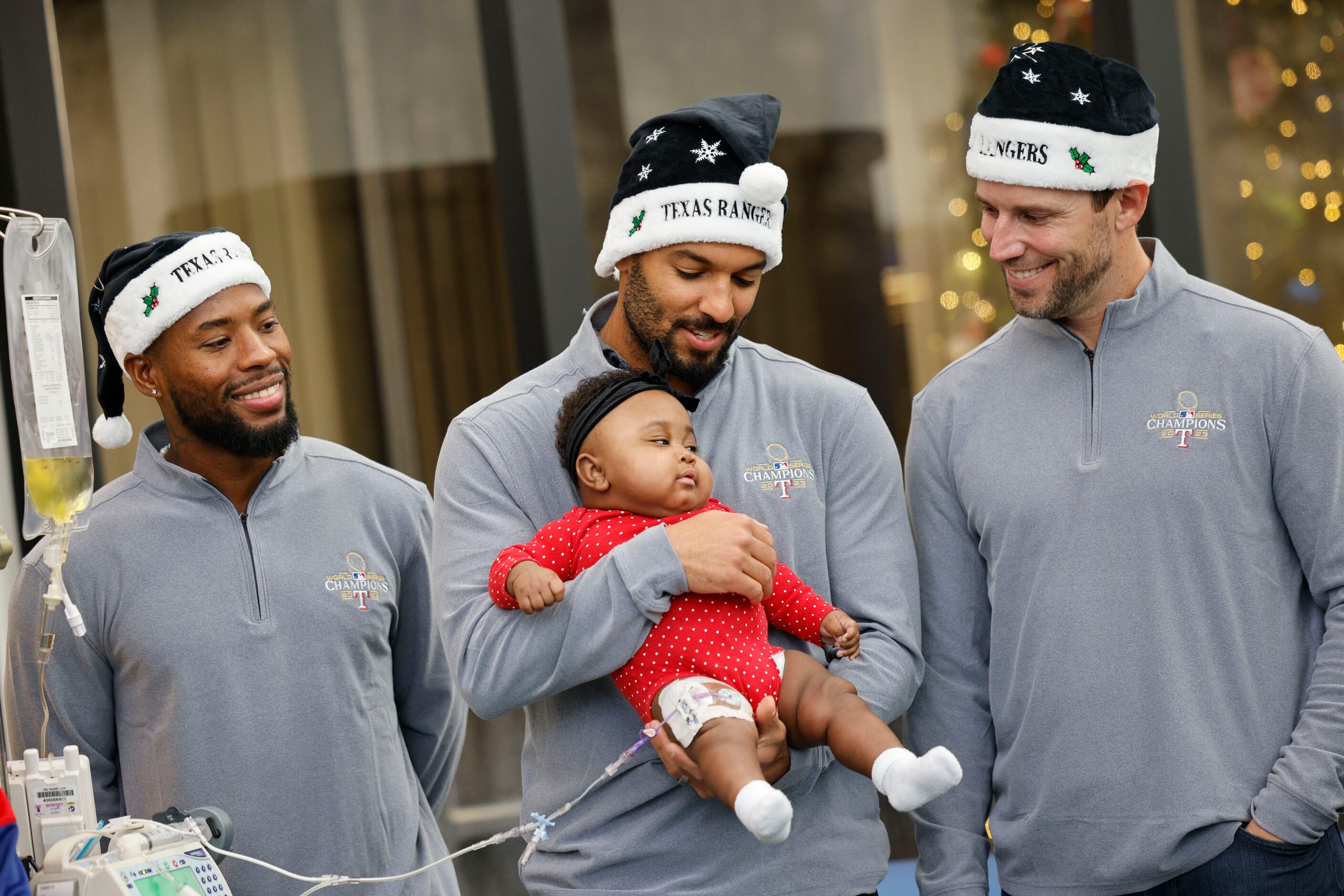 Texas Rangers second baseman Marcus Semien, center, holds Aria Thomas, seven month-old...