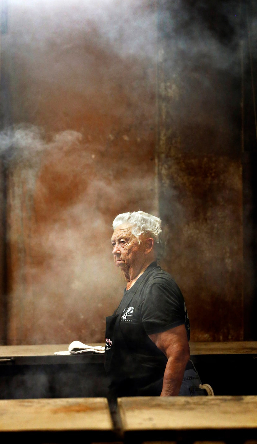 Tootsie Tomanetz makes her way between barbecue pits at Snow's BBQ. She  begins work at 2...