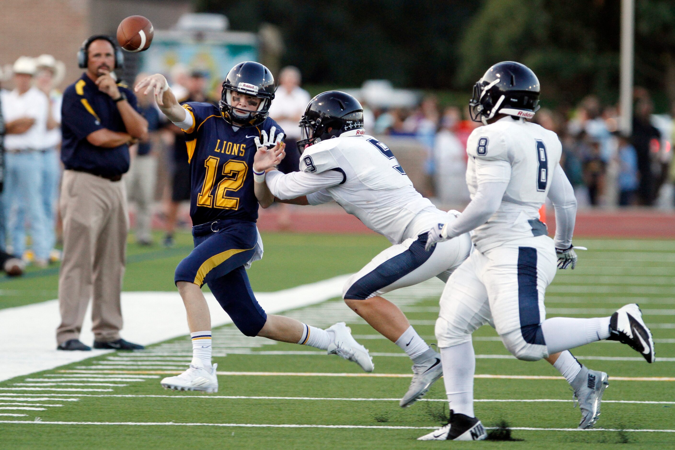 St. Mark's junior quarterback Hyer Thomas (12) throws to a receiver before being pushed out...