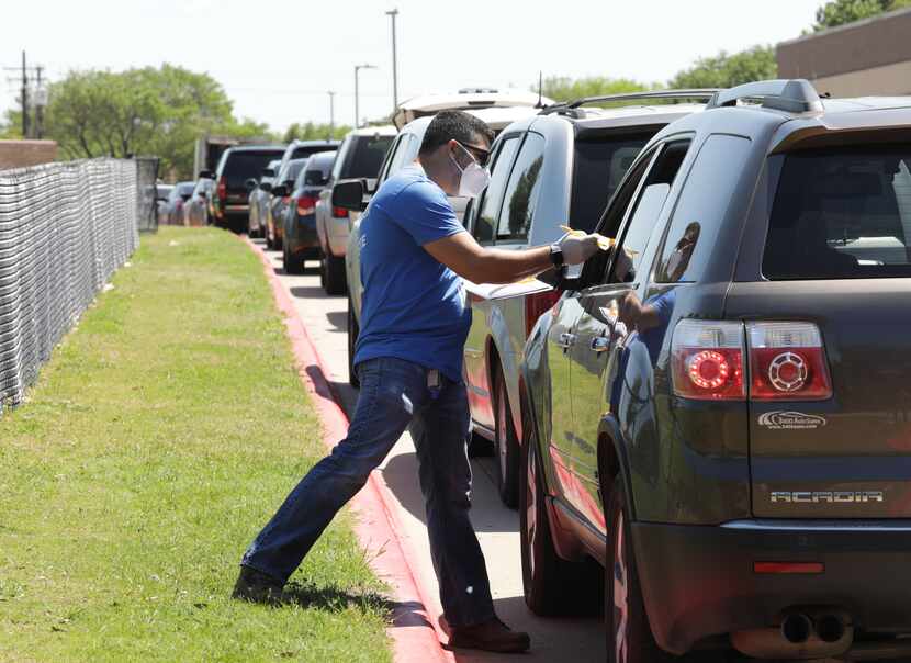 Carlos Castro, a volunteer with Minnie’s Food Pantry, helped hand out food during a recent...