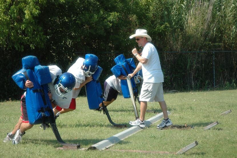 Lakehill head football coach Chris Peacock works with his new players during 2013 summer...