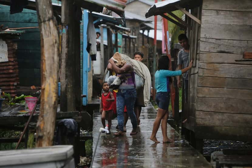 Las personas llevan pertenencias en el barrio “El Canal” antes de llegue el huracán Otto la...