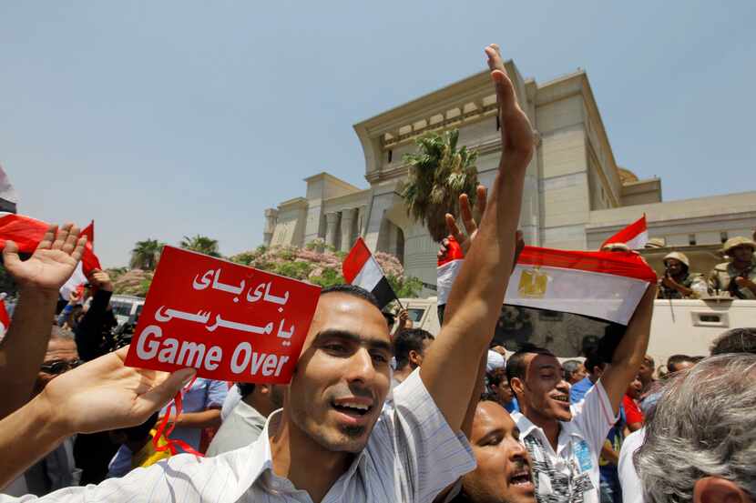 Egyptians celebrate after Egypt's chief justice Adly Mansour is sworn in as the nation's...