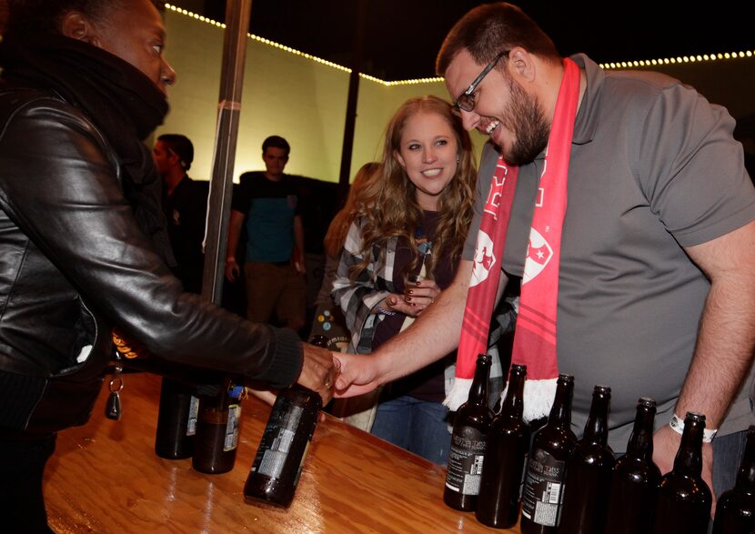 Lorna Christian, left, serves Rachel Browning and TJ Browning a sample of beer during the...