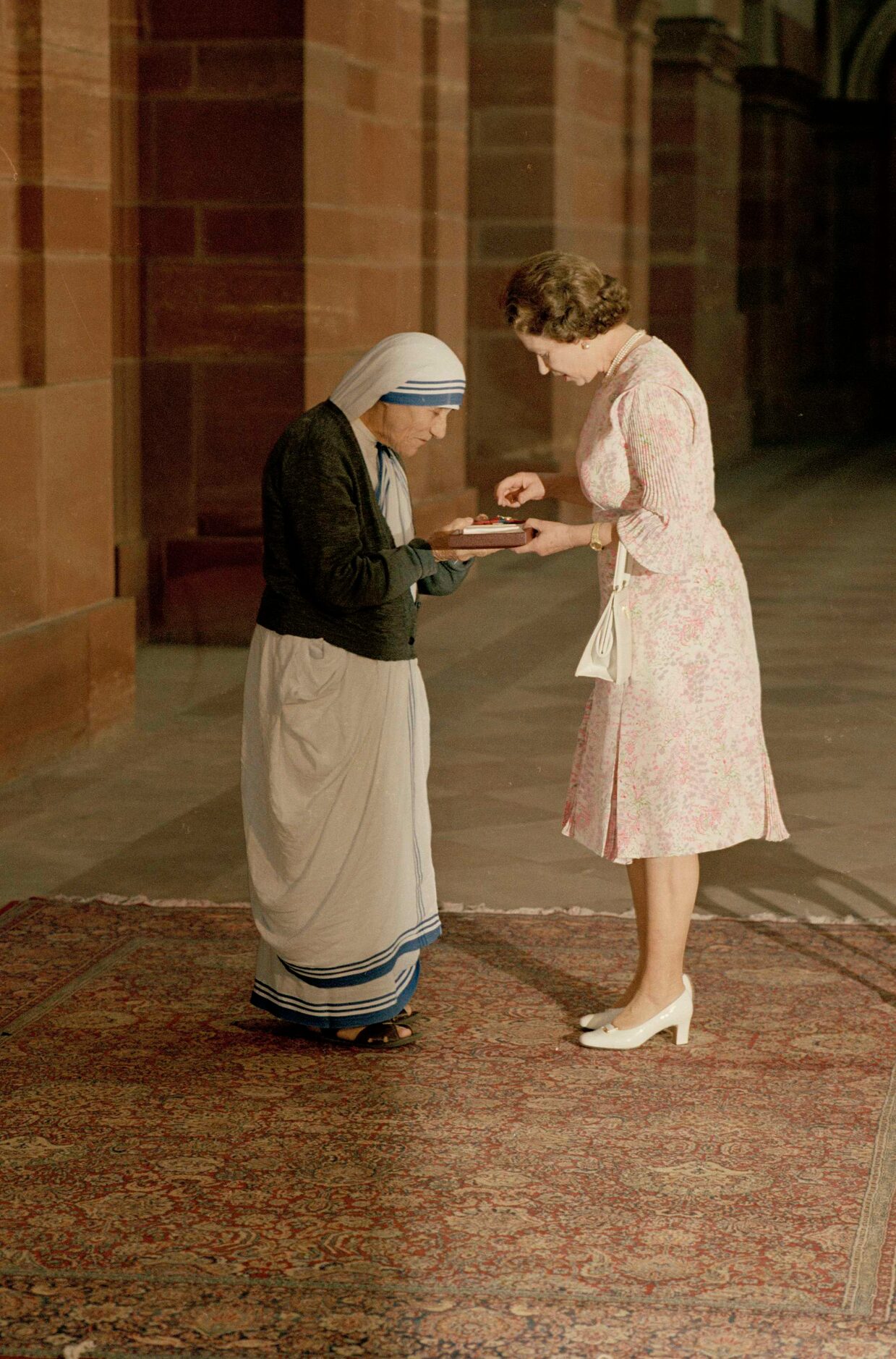 FILE - In this Thursday, Nov. 24, 1983 file photo, the Queen and Mother Teresa look at the...