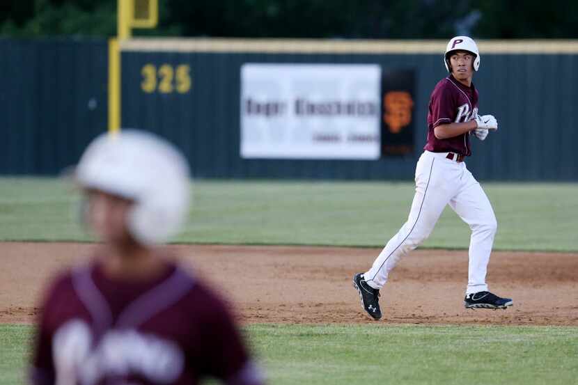 Plano's A.J. Liu (6) moves back to second base after a wild pitch by Rockwall starting...