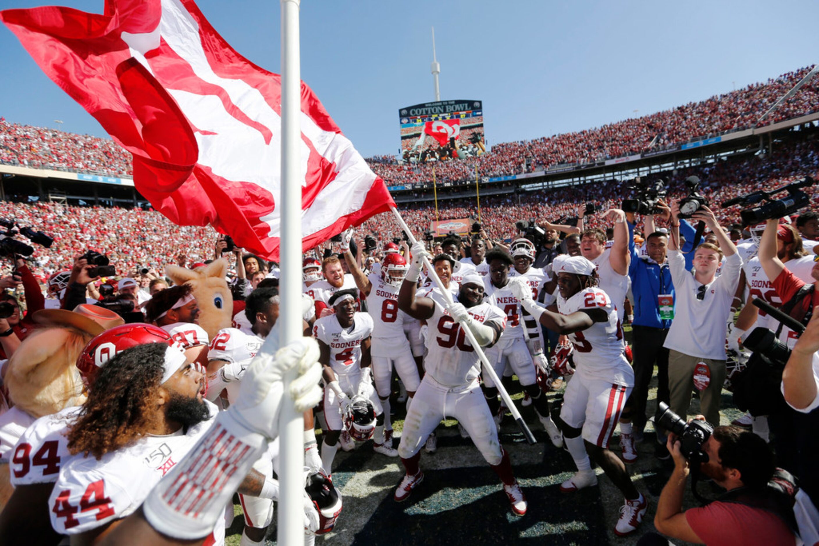 Oklahoma Sooners defensive lineman Neville Gallimore (90) waves the Oklahoma Sooners flag...