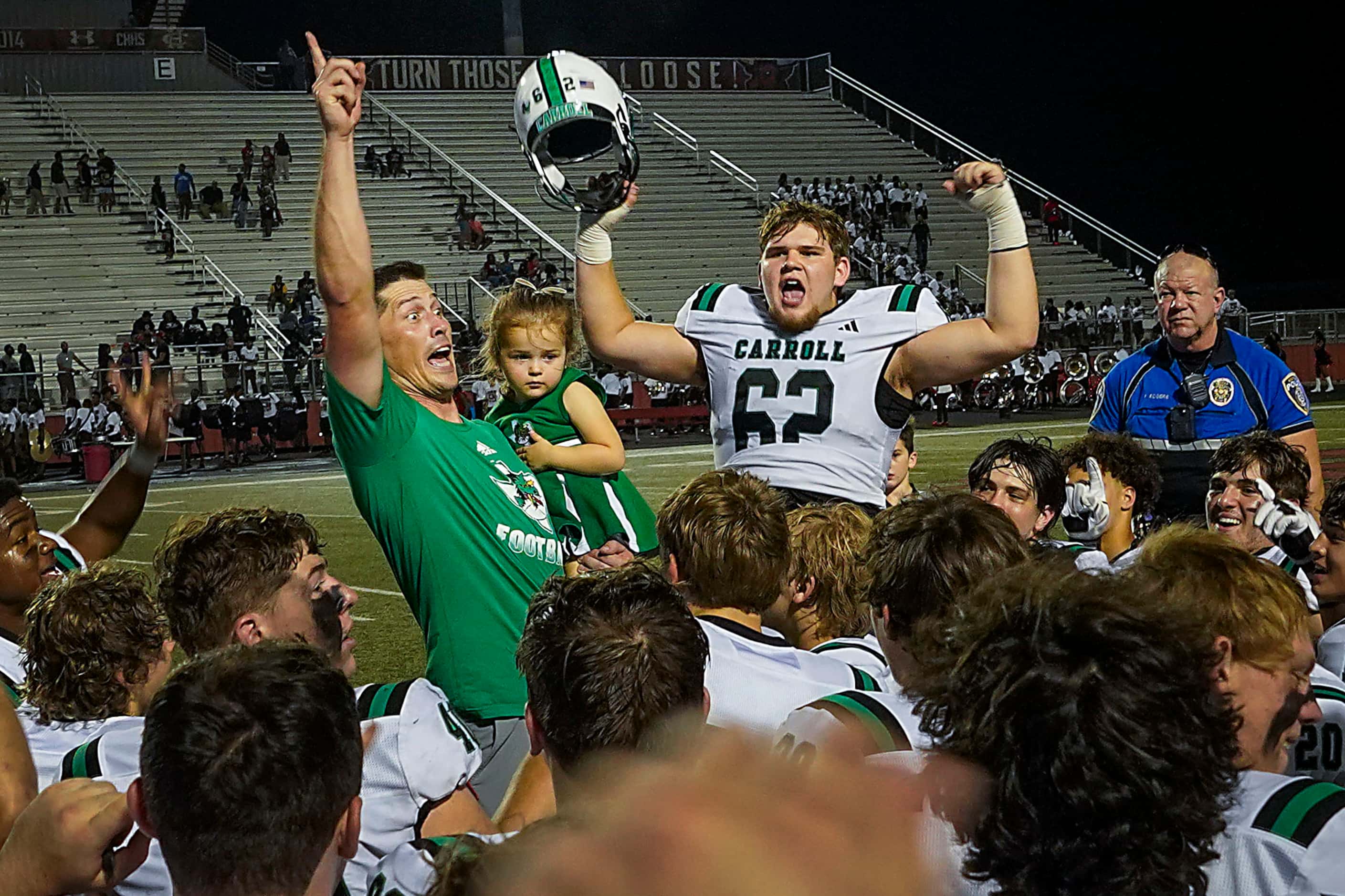 Southlake Carroll head coach Riley Dodge celebrates with players, including offensive...