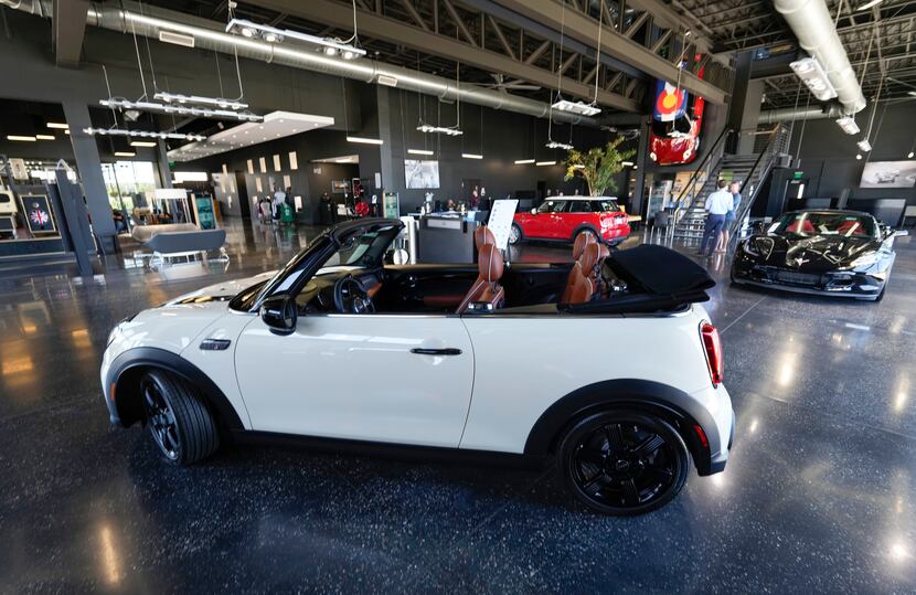 A sales associate talks with a prospective buyer of a Cooper SE electric vehicle on the...
