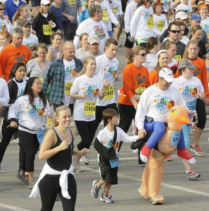 Participants in the YMCA Turkey Trot make their way down Young St. in downtown Dallas...