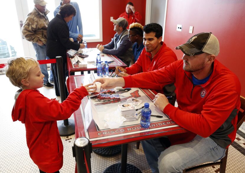 Texas Rangers pitcher Matt Harrison hands back an autographed ball to Colton Wernimont, 6,...