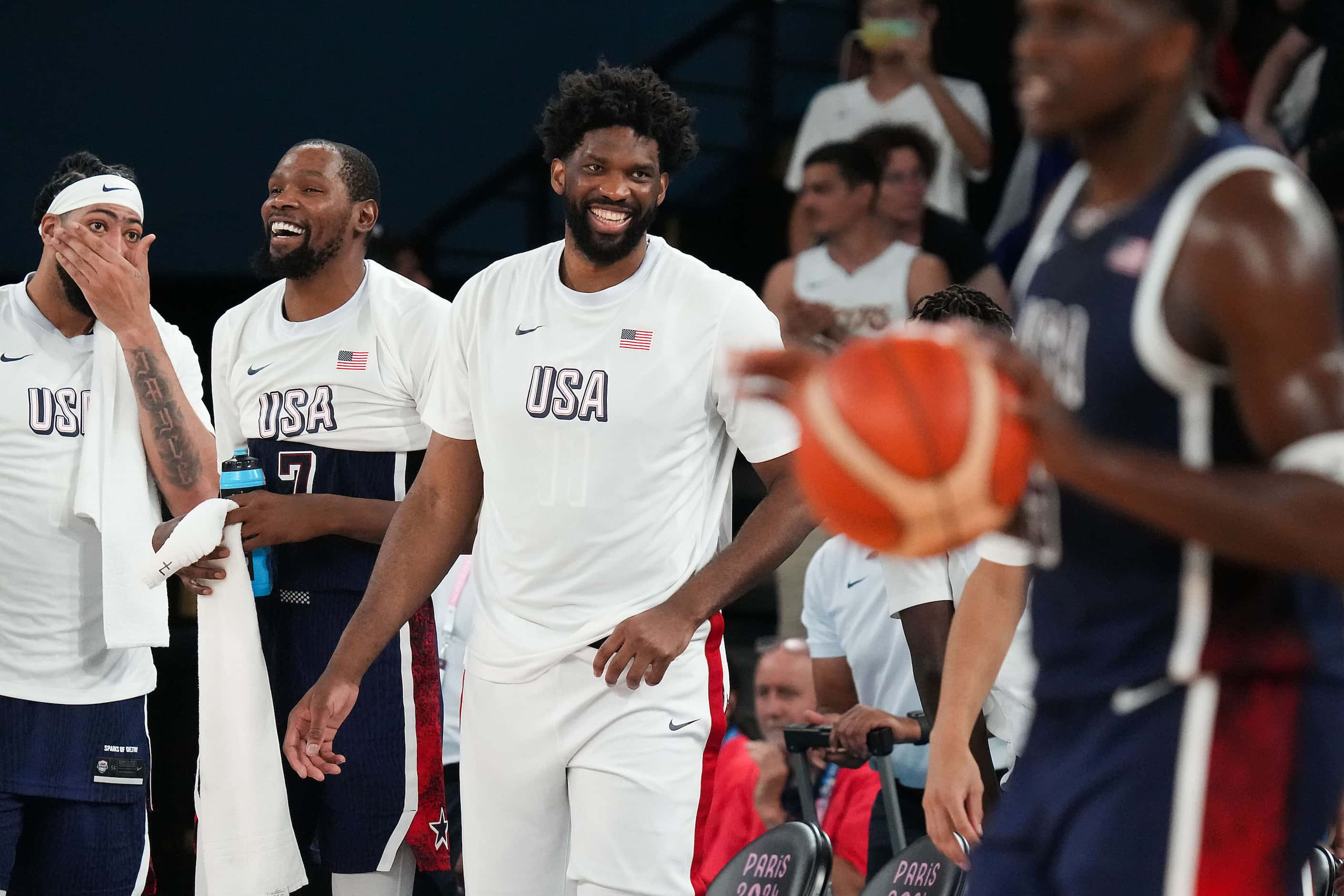 Joel Embiid (11) of the United States laughs with teammates during the final seconds of a...