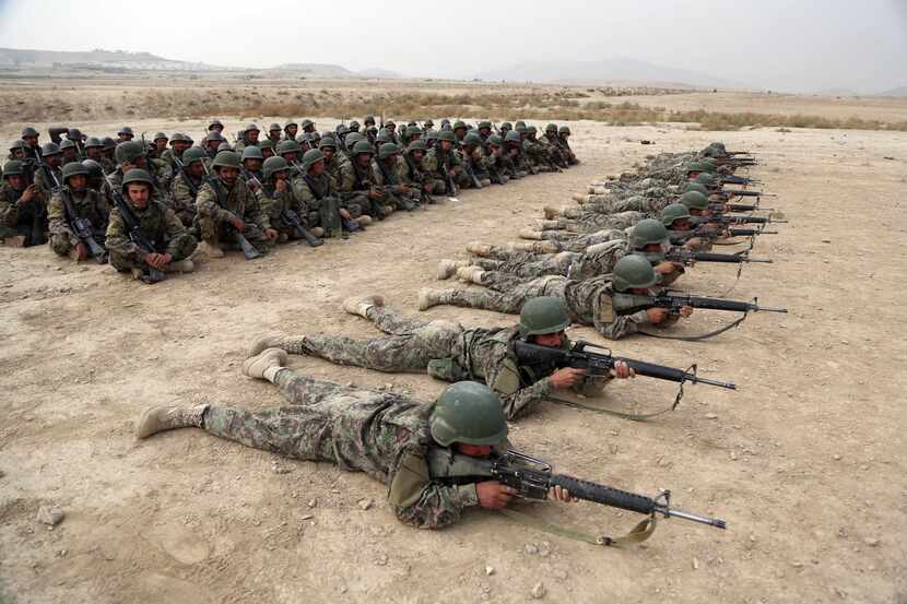 In this 2018 photo, Afghan National Army soldiers carry out an exercise during a live firing...