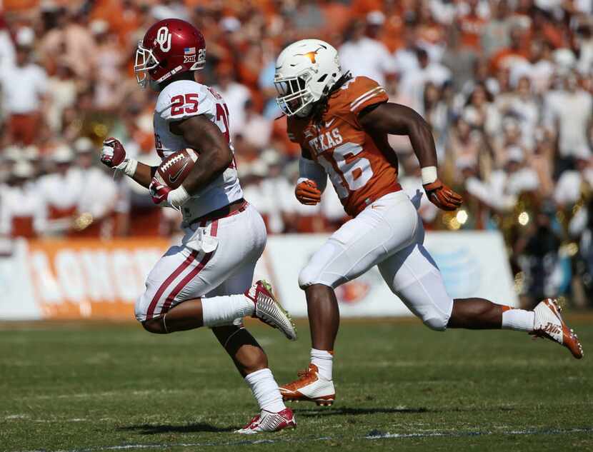 Oklahoma Sooners running back Joe Mixon (25) rushes the ball while being defended by Texas...