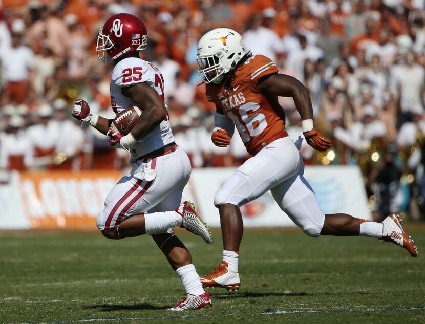 Oklahoma Sooners running back Joe Mixon (25) rushes the ball while being defended by Texas...