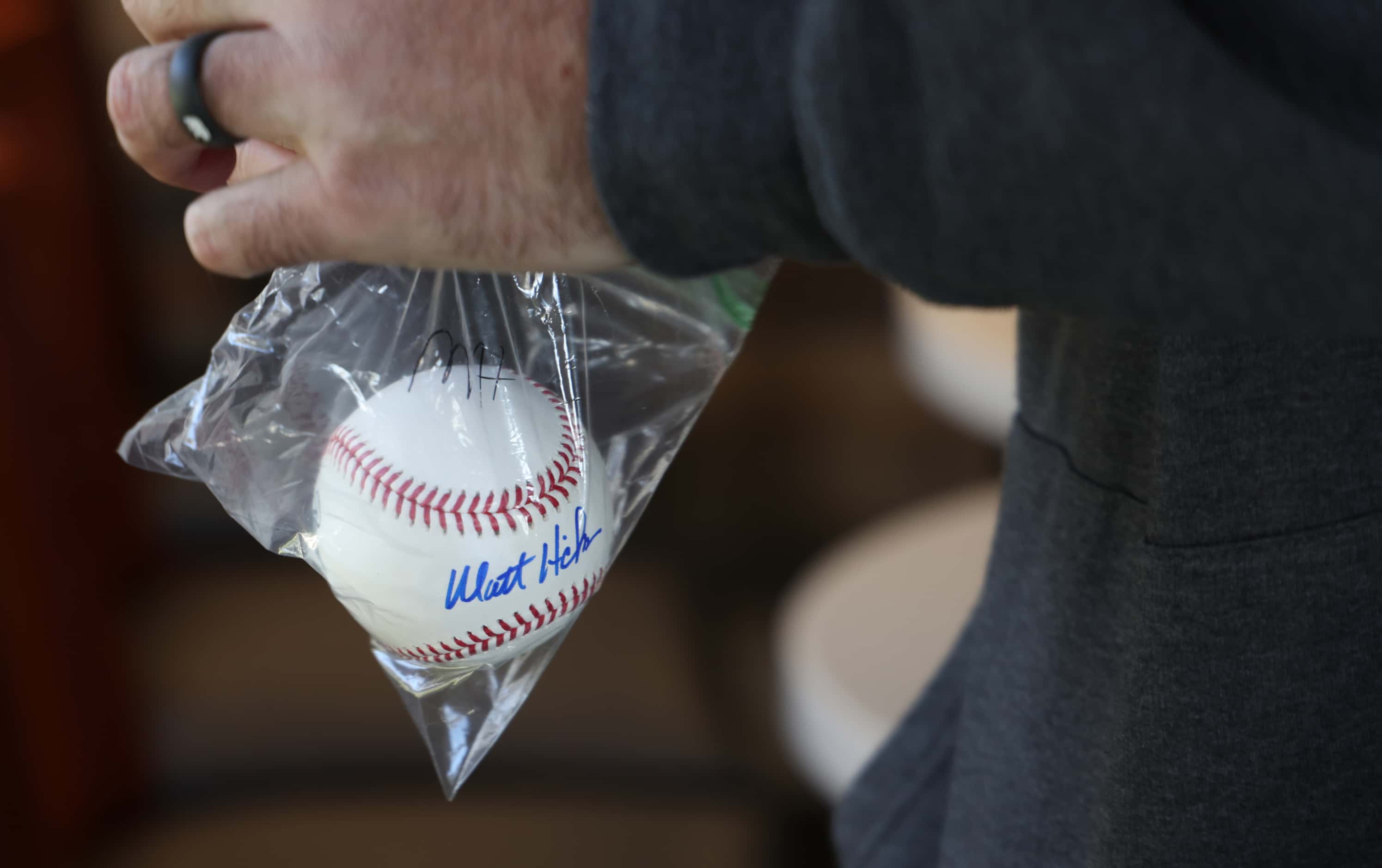 A Texas Rangers fan secures an autographed ball after signed by Rangers radio broadcaster...
