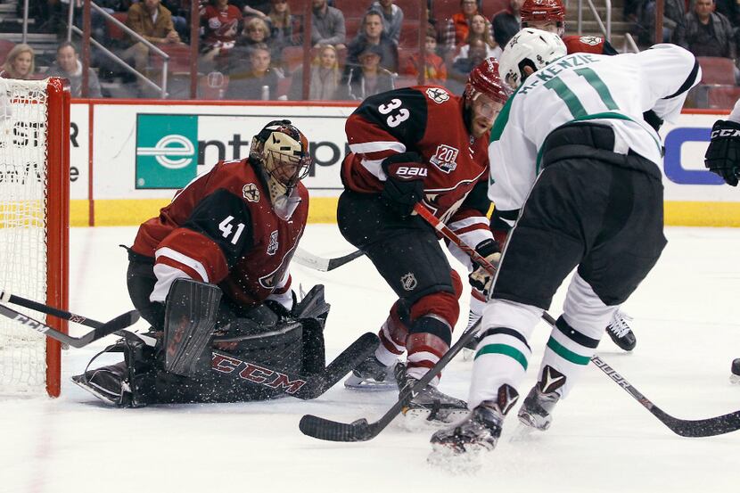 Arizona Coyotes goalie Mike Smith (41) looks to make a save as Dallas Stars' Curtis McKenzie...