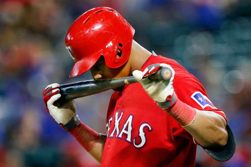 Texas Rangers left fielder Carlos Gomez (14) takes a sniff of his bat before stepping into...