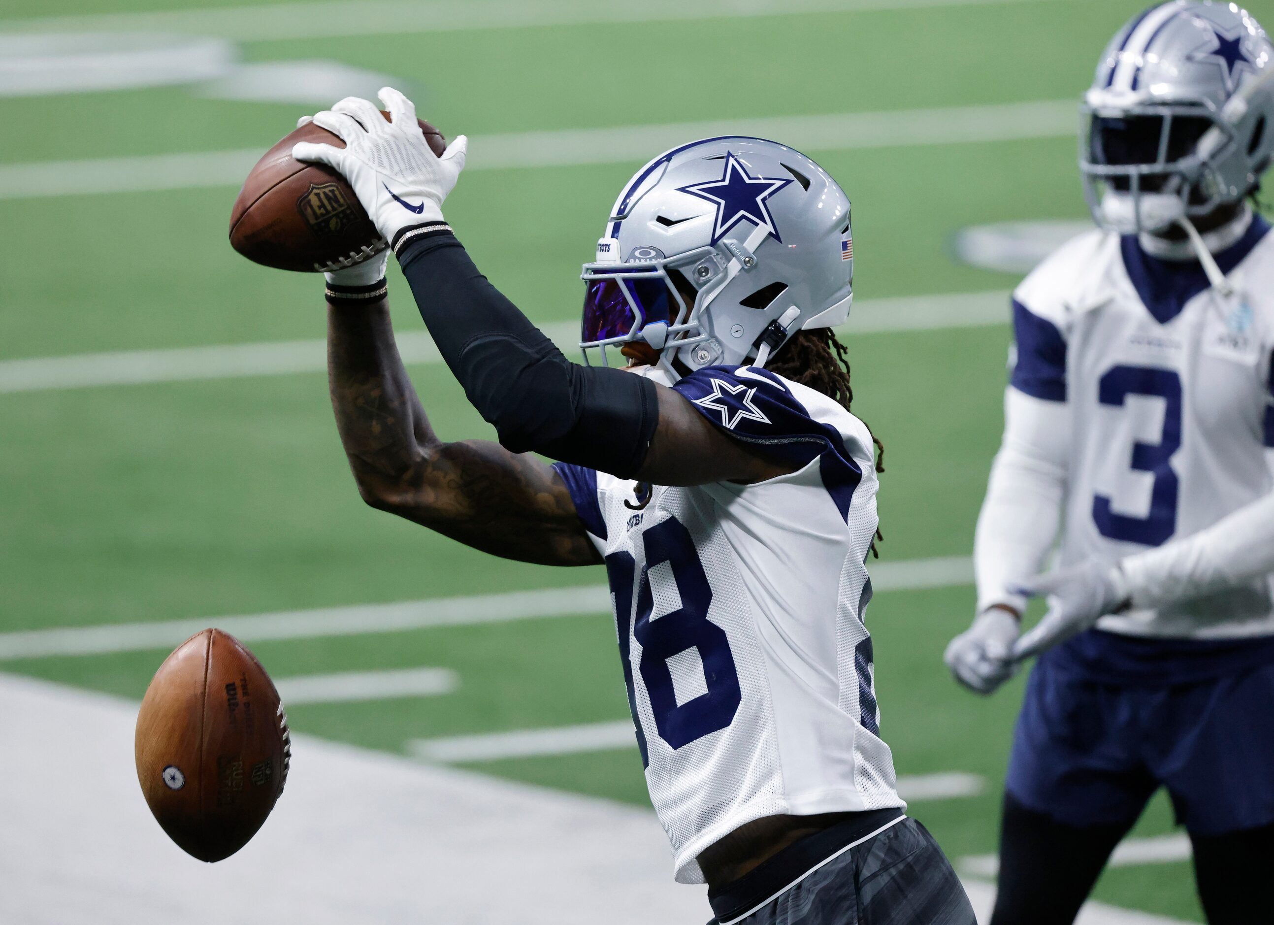 Dallas Cowboys wide receiver CeeDee Lamb (88) catches passes off the throwing machine as he...