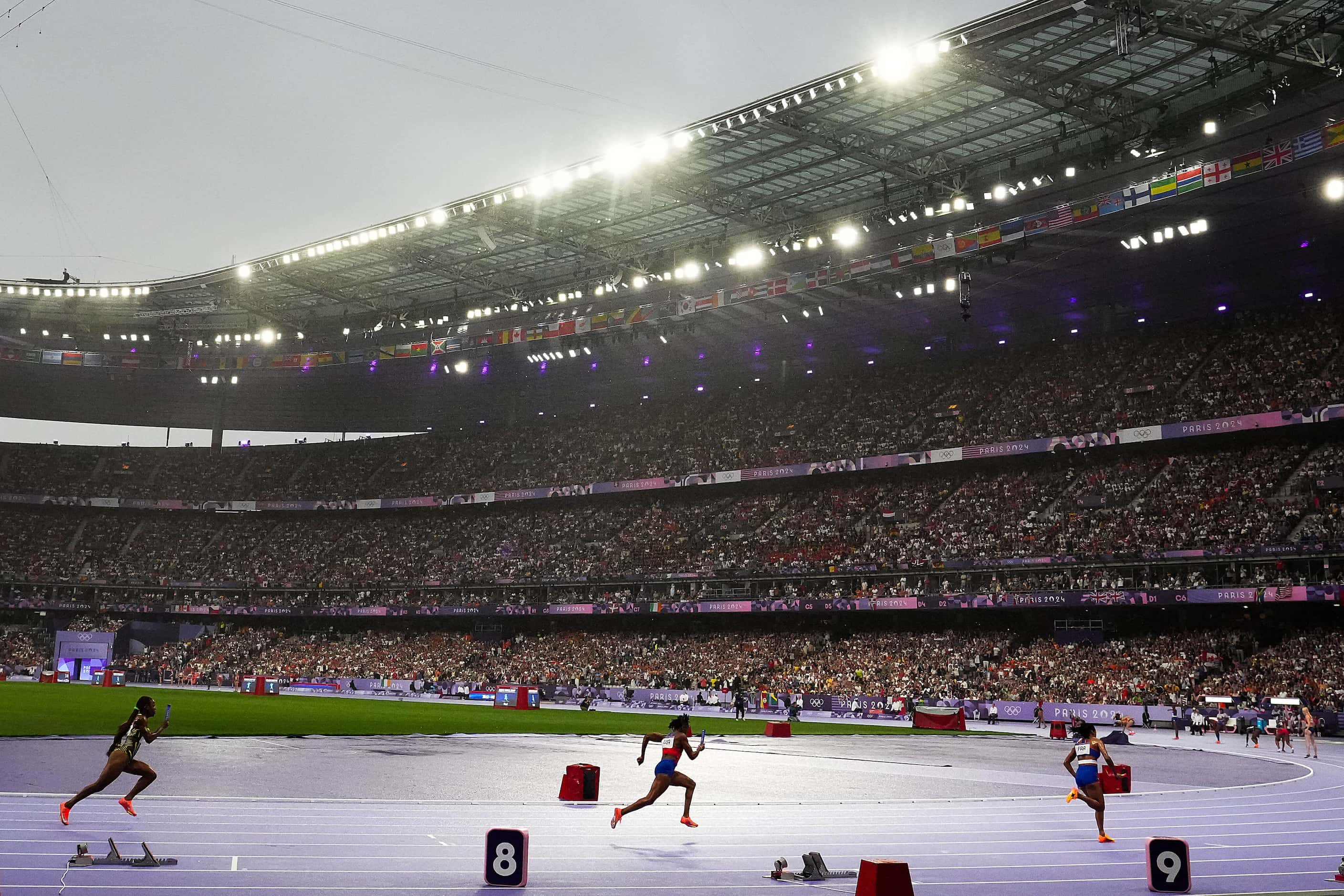 Melissa Jefferson of the United States (center) runs the first leg of the gold medal winning...