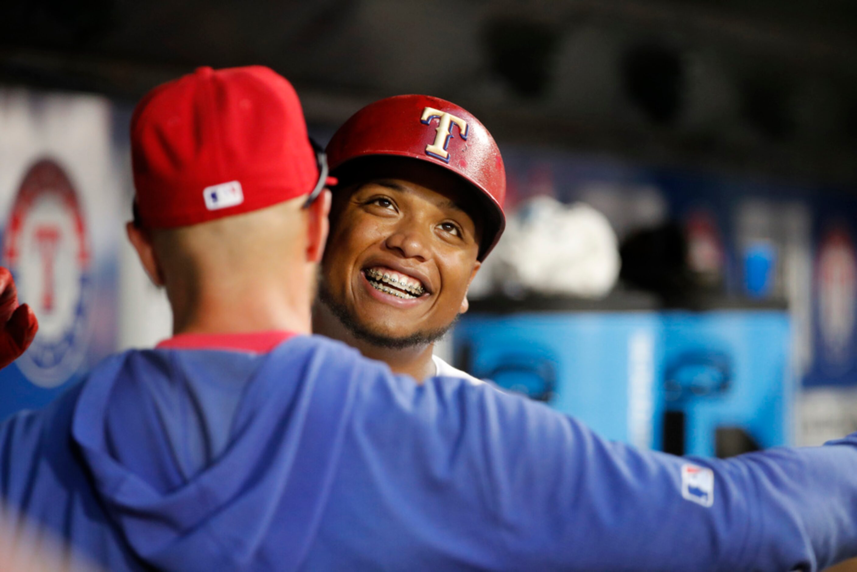 Texas Rangers' Willie Calhoun smiles as he celebrates in the dugout after hitting solo home...