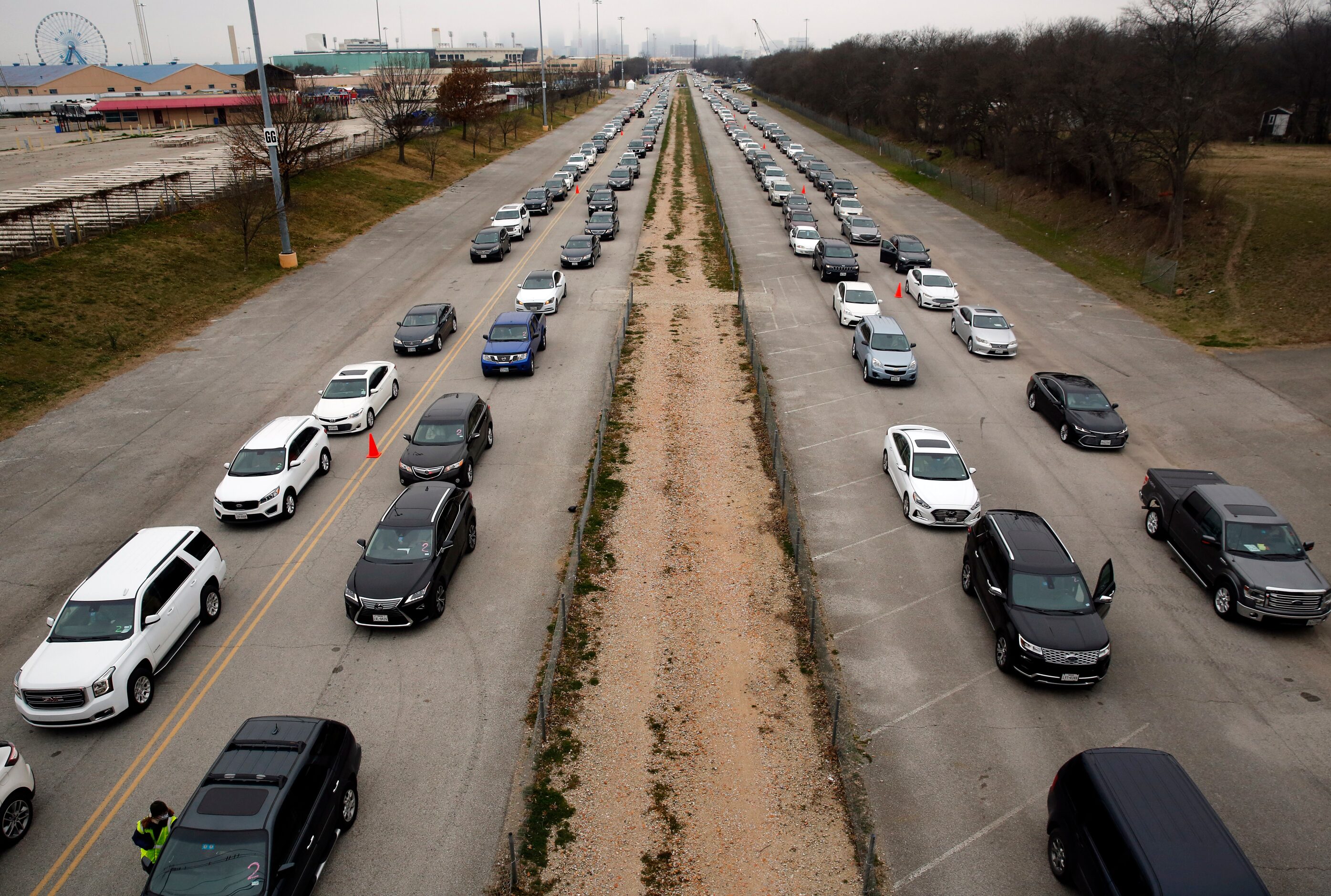 A long line of vehicles line up in Fair Park to receive COVID-19 vaccinations in Dallas,...