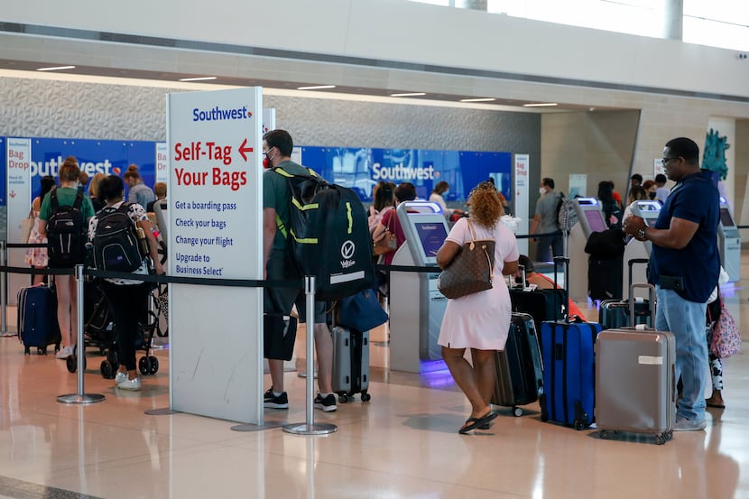 Airline passengers waited to check baggage at a Southwest ticket counter at Dallas Love...