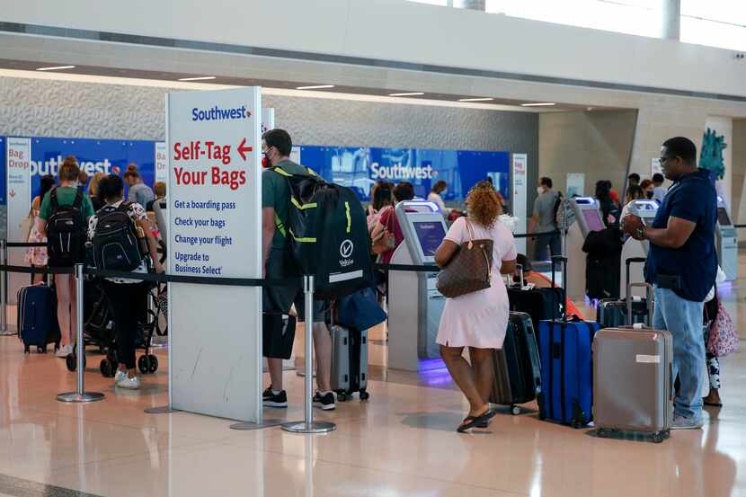 Airline passengers waited to check baggage at a Southwest ticket counter at Dallas Love...