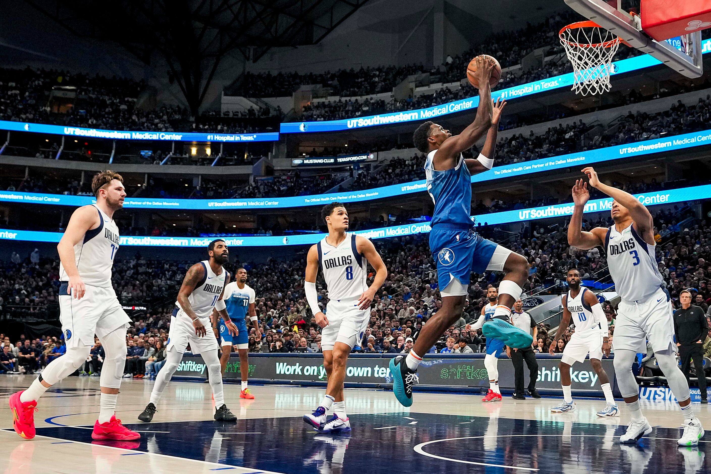 Minnesota Timberwolves guard Anthony Edwards (5) scores past Dallas Mavericks guard Luka...